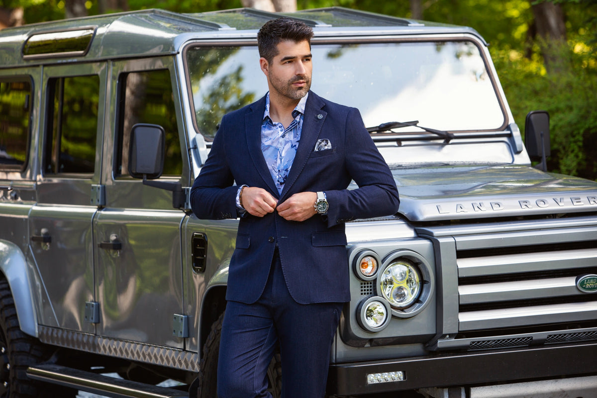 AU NOIR navy tailoring photographed beside a vehicle in the Fall 2026 campaign